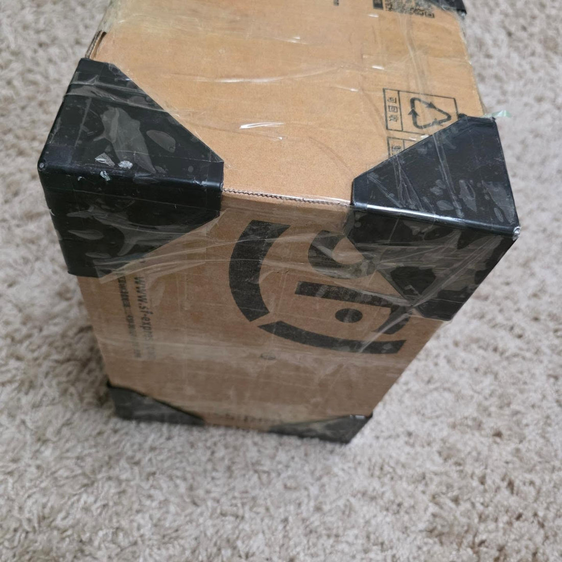 Verzenddoos uit Japan met zwarte tape op de hoeken, in folie gewikkeld